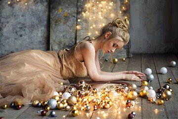 Portrait of an attractive beautiful young girl in a beige evening dress against the background of a...