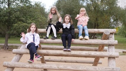 A group of little girls waving goodbye in a city park 4k slow motion