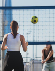 Volleyball game, female team of girls play volleyball, players on the outdoor playground with net...