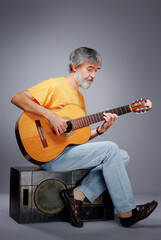 Aged bearded man with an acoustic guitar