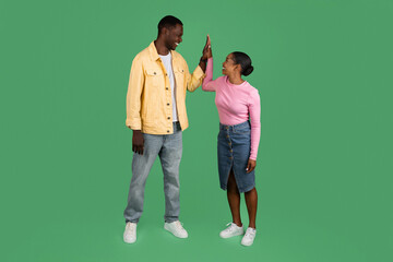 Positive black man and woman giving each other high five