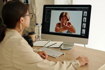 Focus on screen of computer with shots of young female fashion model sitting in isolation and looking at camera during photo session - Powered by Adobe
