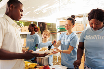 Multicultural women collaborating to distribute donations, provide warm meals and essentials to homeless people and refugees. Together, they support the less fortunate, mitigating hunger and poverty.