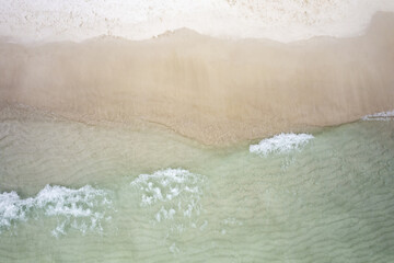 Clear emerald wave on a white sand beach Aerial view drone on a summer day 