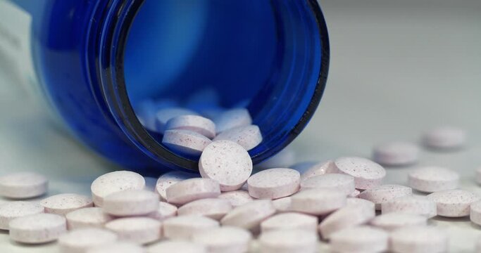 White tablets and blue container for nutritional supplements. In reality these are chromium picolinate tablets. Cinema 4K 60fps video