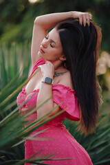 Beautiful woman in pink dress posing at yucca plant - 660160772