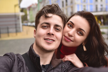 A beautiful couple takes a selfie on the street. A couple in love take a selfie together.