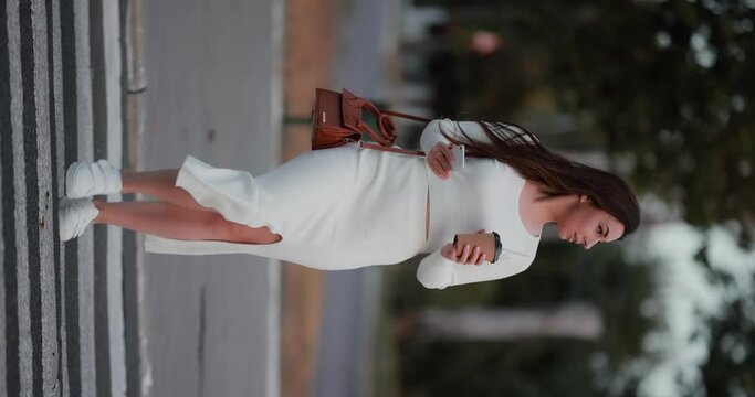 Woman cross the road and drinking coffee cup, slow motion vertical video