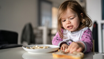 one girl small caucasian toddler female child eat at the table at home
