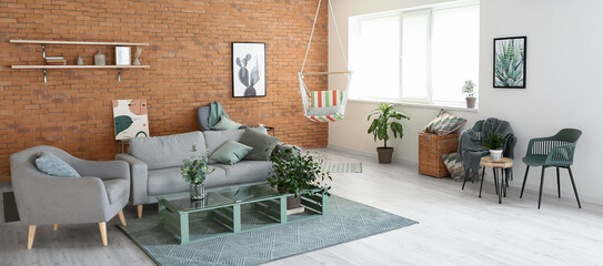 Interior of living room with stylish hammock and grey furniture