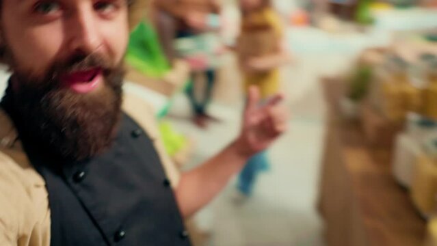 Man films vlog praising hidden gem sustainable local neighborhood supermarket, impressed by high quality vegan products. Healthy living lifestyle influencer shows around newly opened zero waste shop