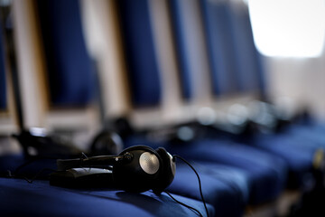 Multiple language translation wireless headphones on blue elegant chairs before conference - 660171198