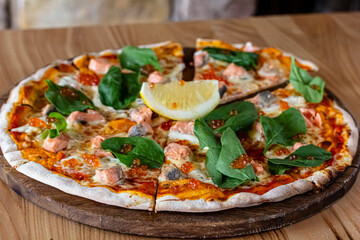 Delicious hot pizza with salmon, red caviar, tomatoes and aragula ready to eat. banner, menu, recipe place for text, top view.