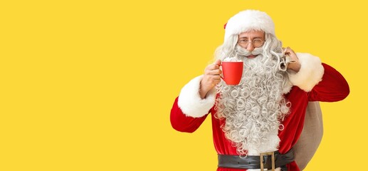 Santa Claus with cup of hot chocolate and bag on yellow background with space for text