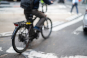 Fototapeta na wymiar Defocused food delivery service bike rider on city street