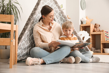 Nanny reading fairy-tale to little boy at home