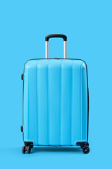 Blue suitcase on color background