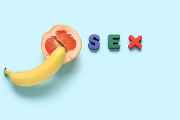 Word sex and cut grapefruit with banana on blue background