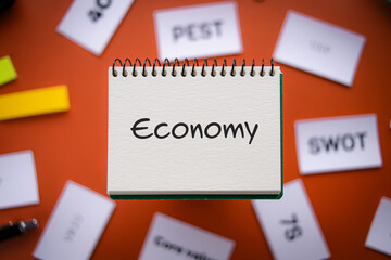 There is notebook with the word Economy. It is as an eye-catching image.