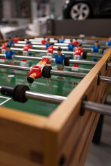 Foosball table, close-up. Football - board game with players, soccer ball and green field.