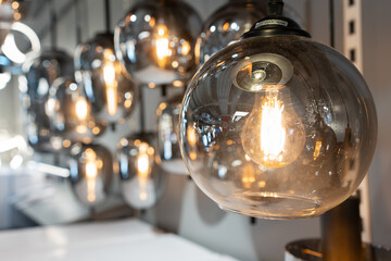 Round glowing tungsten lamp. Vintage tungsten filament multiple lamps of different size and style hanging from the ceiling.