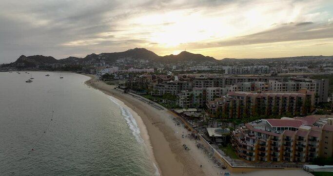Sunrise Flight Over Cabo San Lucas Beach with City and Mountain Silhouettes
