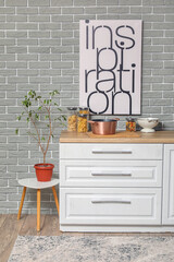 Kitchen counter with cooking pot, cutting board, jars and houseplant