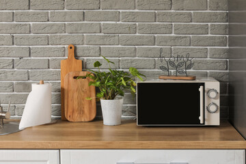 Kitchen counter with microwave oven, houseplant and cutting boards