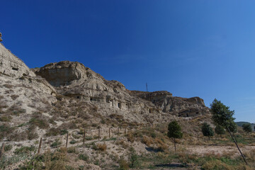 Fototapeta na wymiar Human made caves inside the rock of a hill in Arguedas, Bardenas Reales, Navarra, Spain