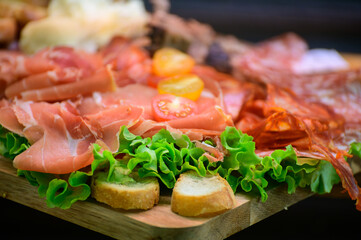 Fresh cuts of French cured sausages, ham, cheeses for party close up