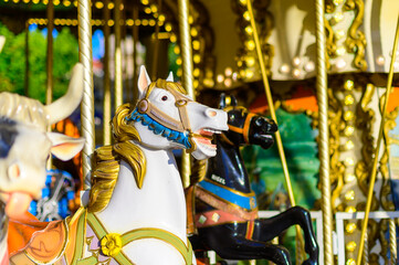 Fototapeta na wymiar Colorful horse on traditional old french caroussel in city park in sunny day