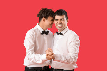 Married gay couple dancing on red background