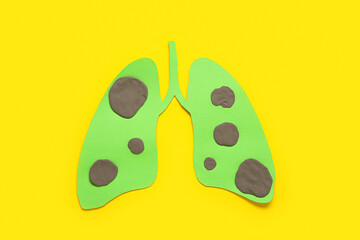 Paper lungs with tumors on yellow background. Lung cancer concept