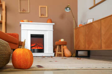 Interior of living room with pumpkins, fireplace and commode