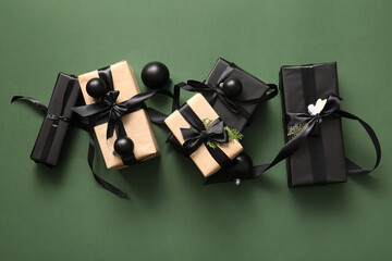 Many gift boxes with coniferous branch and Christmas balls on green background