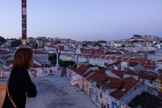 Woman looking at Lisbon cityscape at sunset, Portugal, from Santa Justa Elevator. Lisbon city, Portugal.