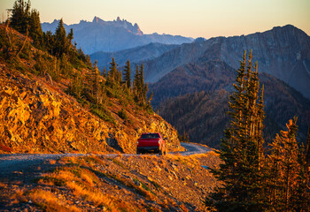 North Cascades National Park scenic landscape. Pasayten Wilderness. Car driving on the gravel road down the mountain on sunset. Slate Peak Lookout. Cascade mountains in Pacific Northwest. 