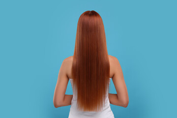 Naklejka premium Woman with healthy hair after treatment on light blue background, back view