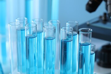 Test tubes with light blue liquid in laboratory, closeup