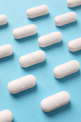 Obraz na płótnie Canvas White pills on light blue background, above view
