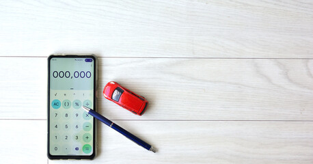 スマートフォンとミニカーで表現する車の維持費のイメージ画像