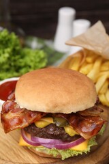 Tasty burger with bacon, vegetables and patty on wooden board, closeup