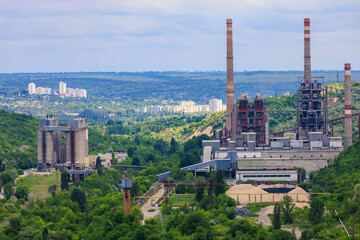 Fototapeta premium Plant or factory. Industrial area in a picturesque beautiful green area. Background with selective focus and copy space