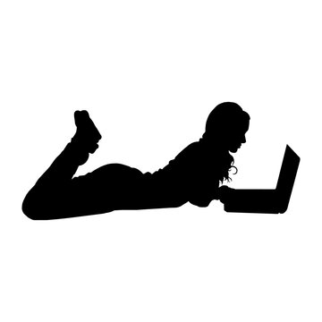 Silhouette of a person playing on a laptop