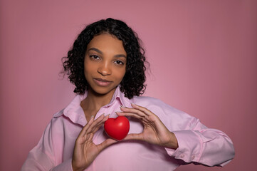 Attractive dark skinned girl holding heart. Valentines day or anniversary concept