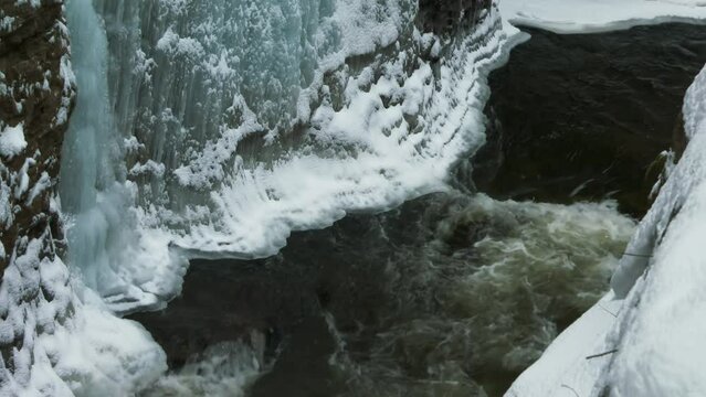 Iced covered gorge cliff and flowing river, Ausable Chasm in Adirondacks