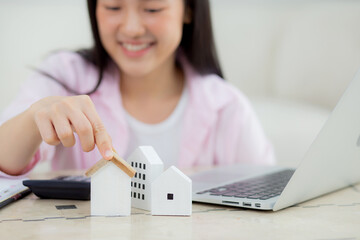 Young asian woman calculate cost and investment to finance about residential and real estate at home, female planning house tax and asset for assess and strategy to success, business and insurance.