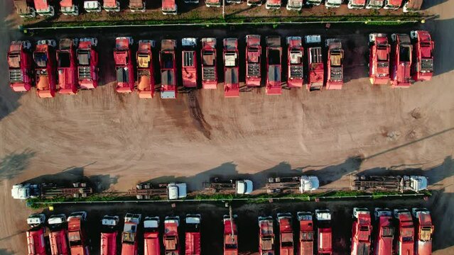 top down aerial of red garbage trucks in rows. Recycling garbage collectors dump trucks. Household waste management industry concept. Rockford Illinois USA