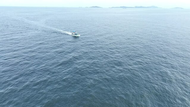Fishing boat returns to port after a long night - at Thailand. Top view of Fishing Boat running verry fast on the sea to port.