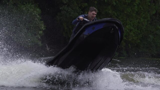 Stylish extreme sport jet ski tricks jumping on fresh water in Canada